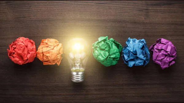 Creative ideas with colorful crumpled papers and lightbulb